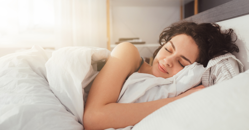 woman sleeping peacefully in well lit bedroom