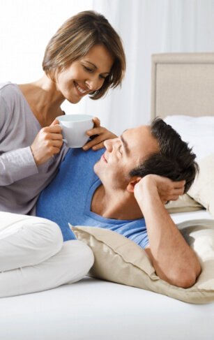 A couple enjoying coffee together in bed