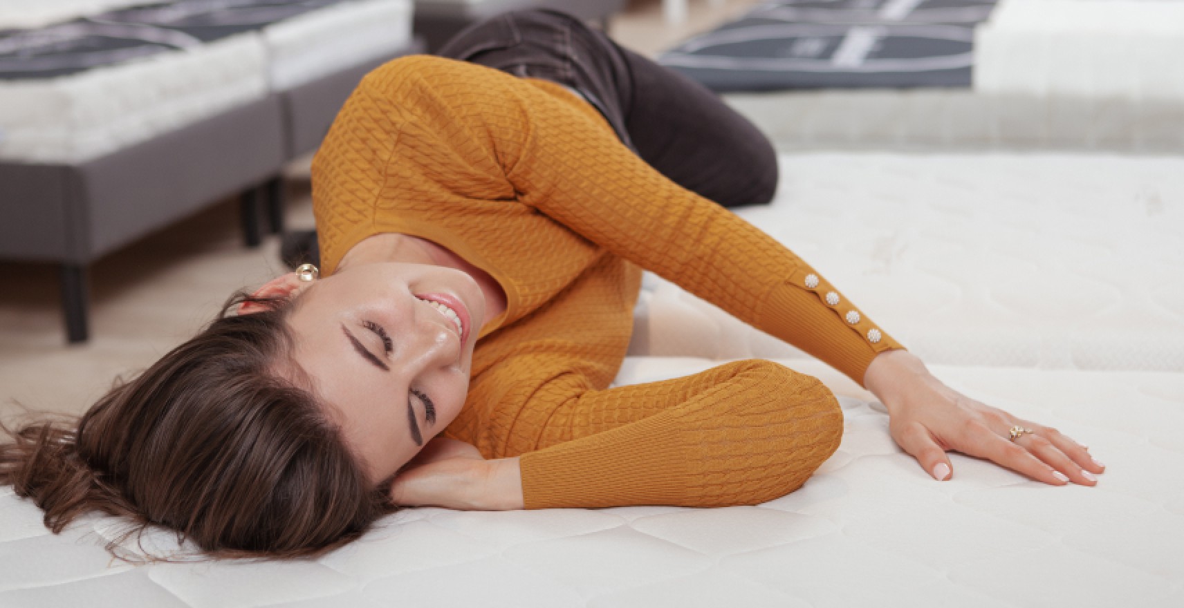 Woman trying out new mattress in store
