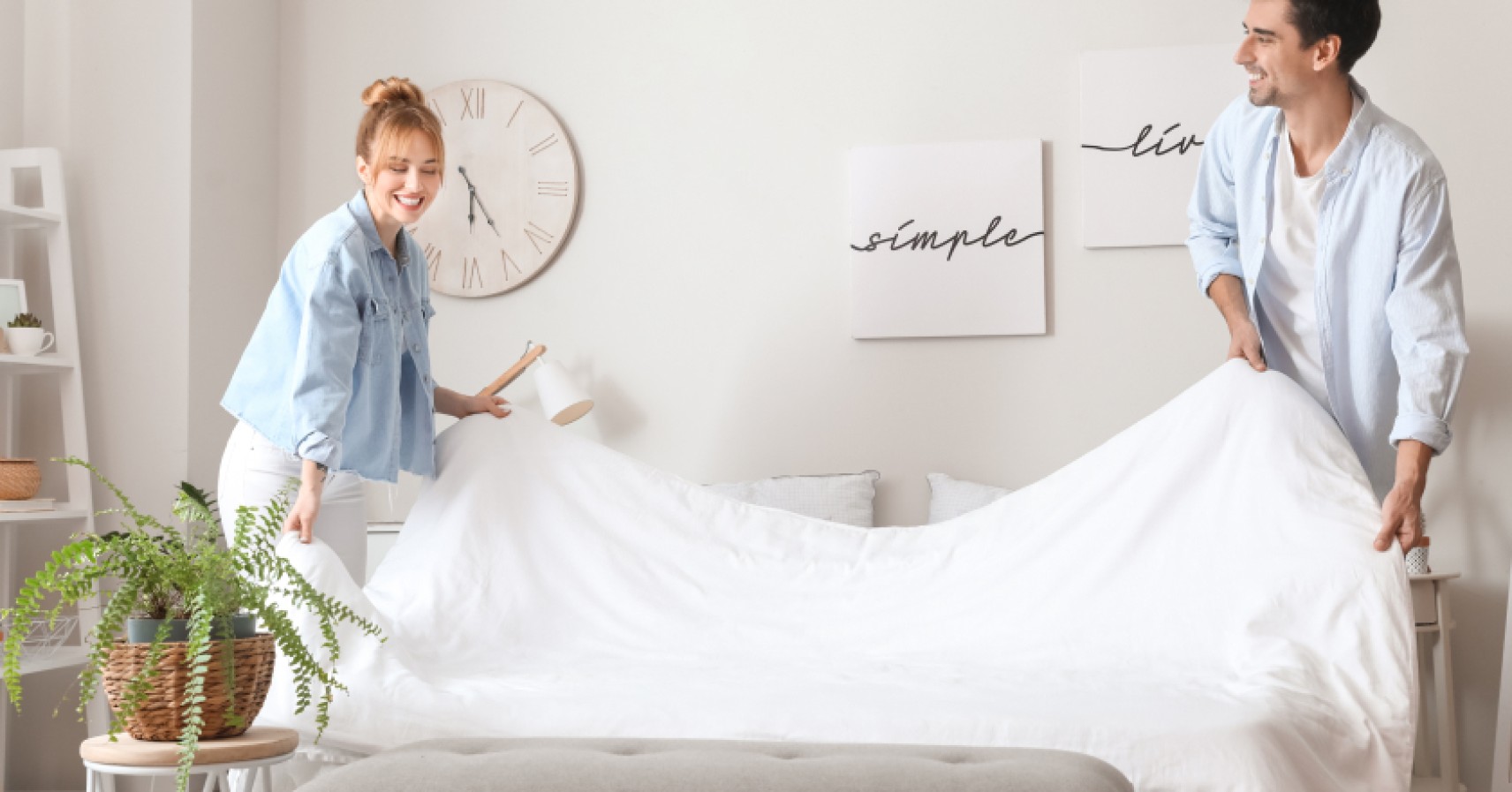 Couple making the bed together