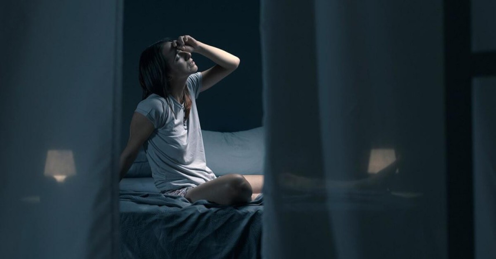 A person sleeping peacefully in a bed with a fan