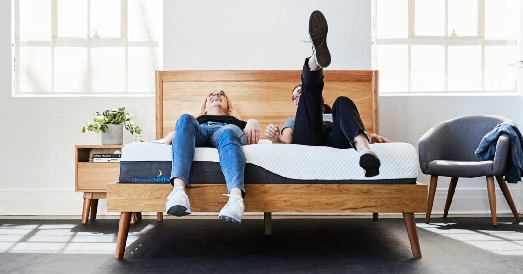 Two young women lying on a mattress together