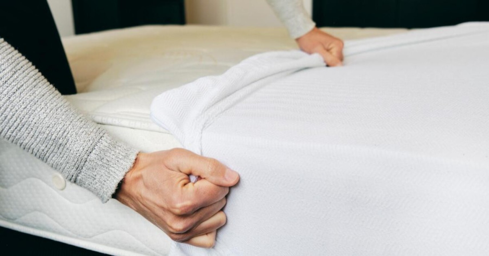 A close-up of a white mattress protector on a bed