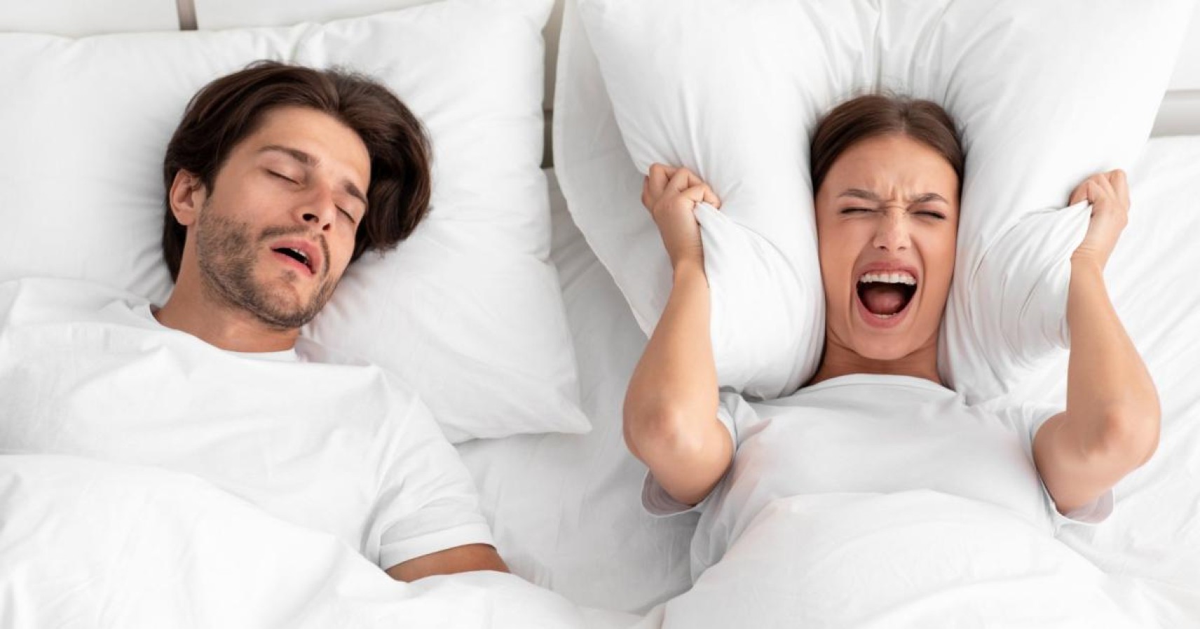 A man sleeping peacefully next to a screaming woman